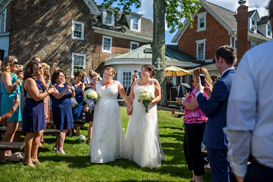Two gay brides walk down the isle at their wedding ceremony in NJ.